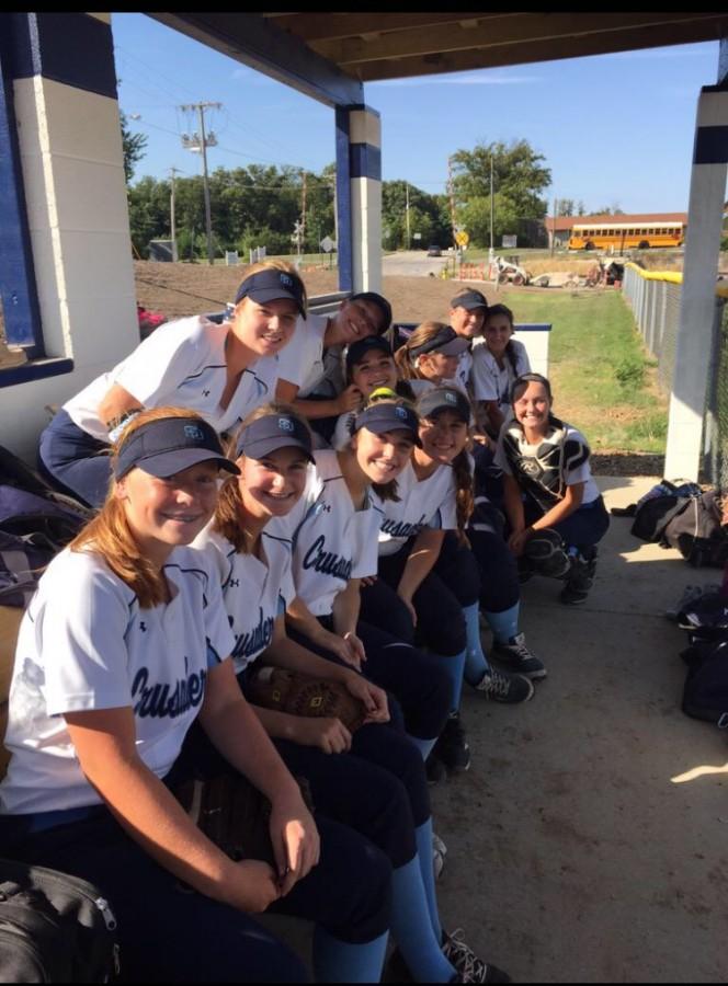 The ladies pose for a picture in the dugout. 