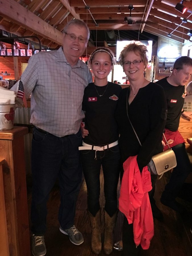 Senior Lexi Browning with her grandparents while working at Texas Road House