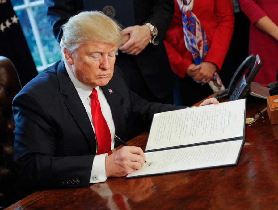 President Donald Trump signs an executive order in the Oval Office of the White House in Washington, Friday, Feb. 3, 2017. Trump signed an executive order that will direct the Treasury secretary to review the 2010 Dodd-Frank financial oversight law, which reshaped financial regulation after 2008-2009 crisis. (AP Photo/Pablo Martinez Monsivais)