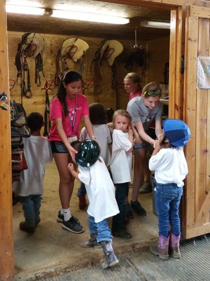 Senior Annika Meyer and Whole Kids Outreach counselors prepare children for horseback riding.