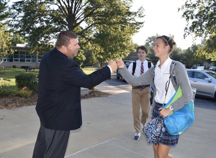 Mr. Welby gives his infamous fist bump to senior Emma Henke.