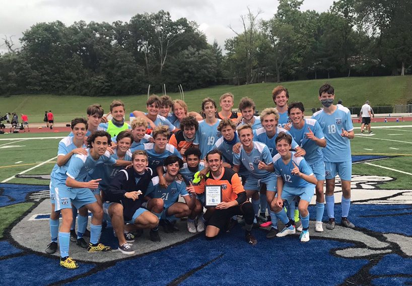 The varsity boys soccer team celebrates after their tournament win 
