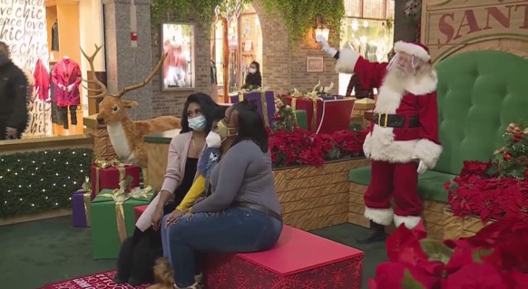 At West County mall, this family snaps a pic with Santa while still wearing masks and staying social distant 
