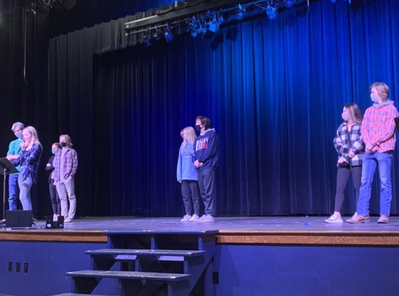 The class of 2022 snowcoming court (Alli Herbert and Garrett Havrilla, Zach Fink and Paige Deeken, and Mia Pointer and Grant Richards from right to left) stand on stage for the junior pep rally. 