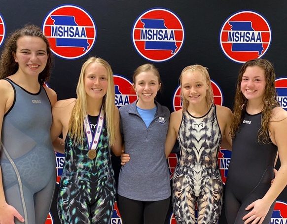 From left to right: Caroline Cunningham, Kallie Nero, Coach Honerkamp, Sydney Pickett, and Elise Newman celebrate the swim teams’ success at state. 