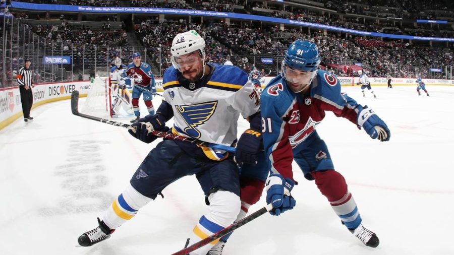 Justin Faulk and Name Kadri battle for a loose puck.