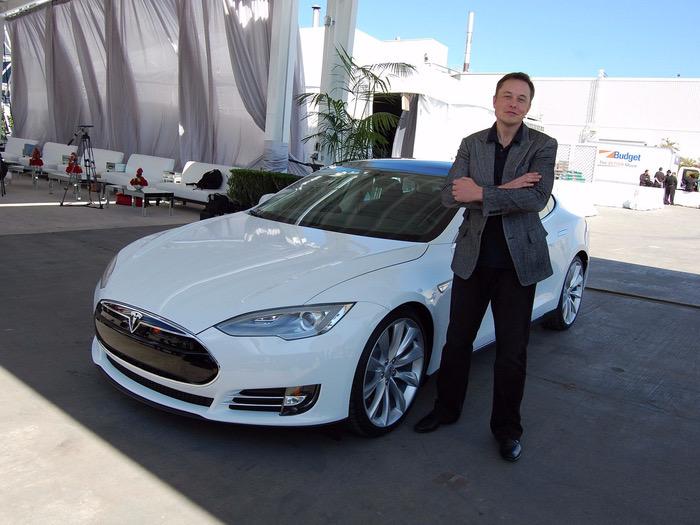Elon Musk stands beside the  modern 2017 Tesla Model 3
