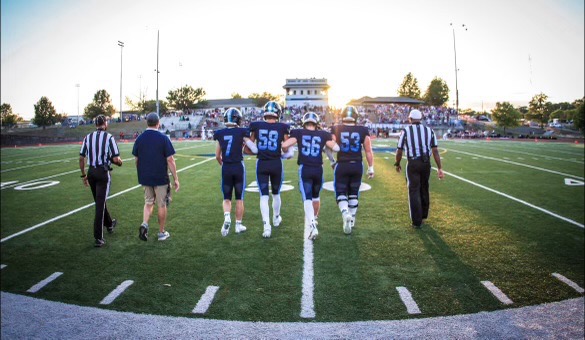 John Moeller takes the field alongside Saint Dominc's team captains 